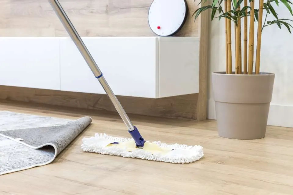 Damp microfiber mop cleaning a luxury vinyl plank floor